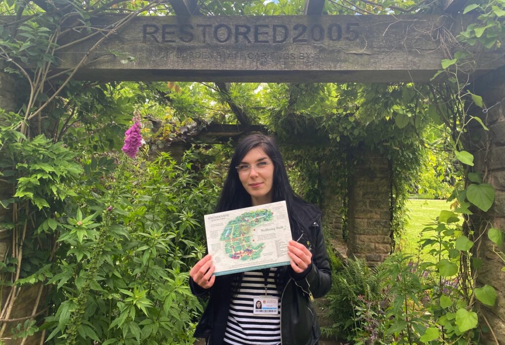 Adriana holding up the illustrated map of Winterbourne